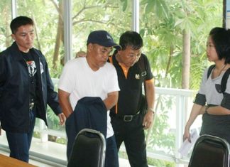 “I’m innocent.” Officials lead away Prayong Thongdeewong after charging him with two acts of vandalism that cost the city as much as 30 million baht each.